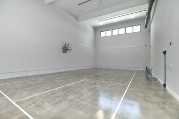 a large room with white walls and concrete floors and a window
